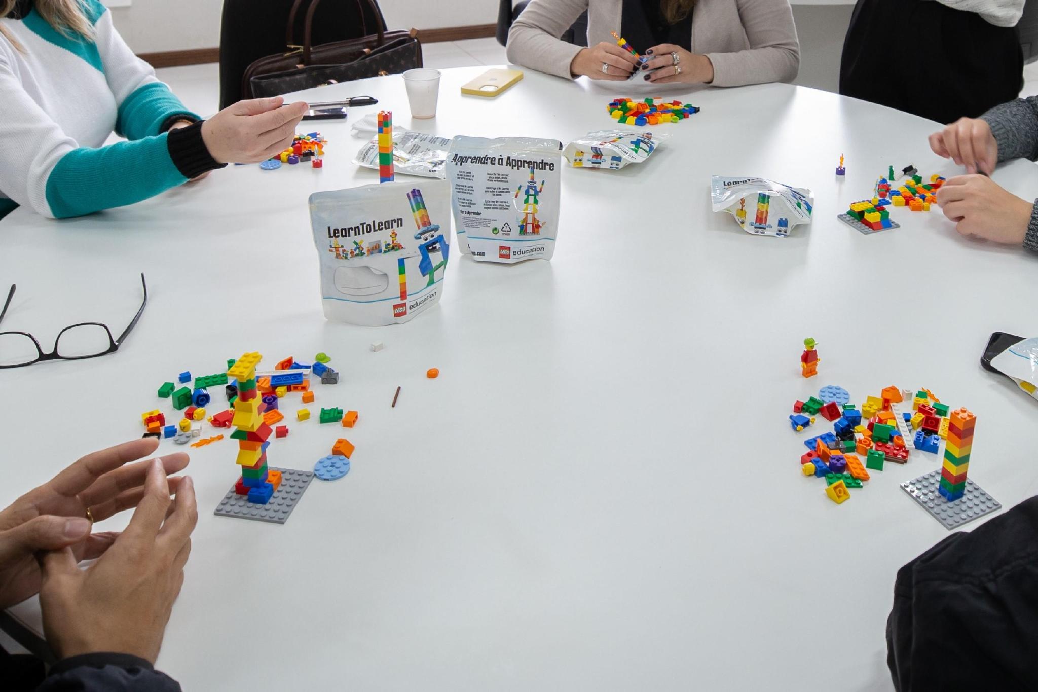 Imagem mostra mãos e peças de LEGO durante metodologia Lego Serious Play
